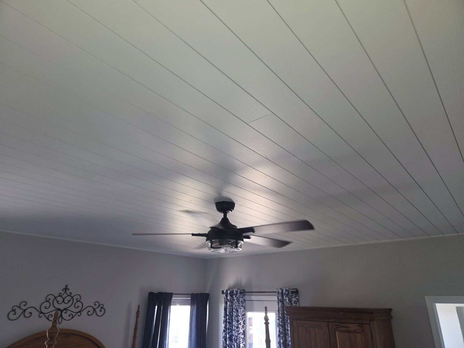 Ceiling fan installed on a white shiplap bedroom ceiling